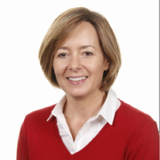 Photo of woman with brown medium length hair smiling, wearing a red jumper over a white shirt.